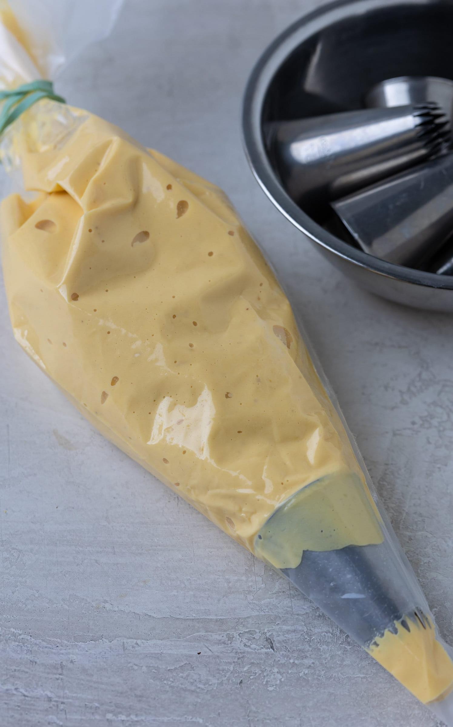 Deviled egg filling in a clear piping bag with a star tip for piping.