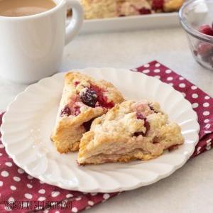 white chocolate cranberry scones on small plate close up